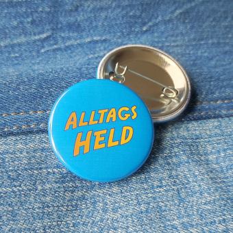 Ansteckbutton Alltagsheld auf Jeans mit Rückseite